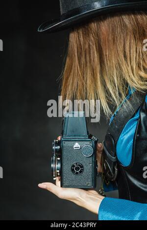 Fotografia e stile retrò. Vintage giovane ragazza attraente detiene il vecchio di età compresa la fotocamera. Steampunk fotografo di prendere foto. Foto Stock