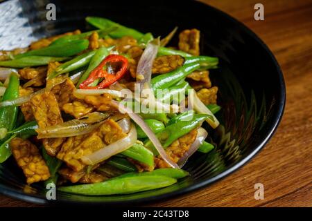 Fagioli lunghi si mescolano fritti con tempe e acciughe. Foto Stock