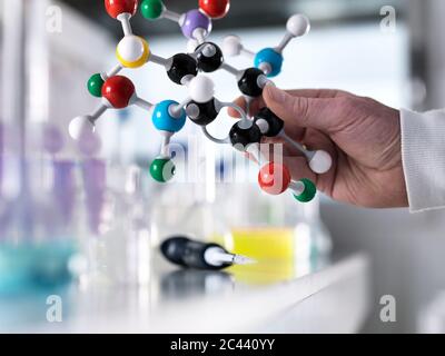 Ritagliate la mano di scienziato maschio tenendo palla e stick modello in laboratorio Foto Stock