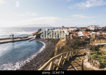 Case in città dal mare contro il cielo in giornata di sole, Corvo, Azzorre, Portogallo Foto Stock