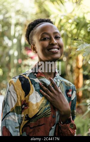 Ritratto di giovane donna alla moda in giardino Foto Stock