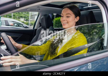 Ritratto di donna sorridente con auto guida Foto Stock