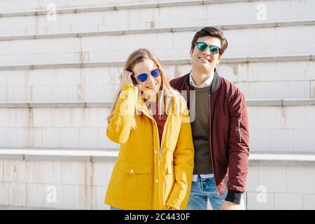 Ritratto di giovane coppia felice in piedi alle scale Foto Stock
