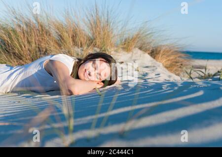 Ritratto di donna sorridente con occhi chiusi rilassante sulla spiaggia, Sardegna, Italia Foto Stock