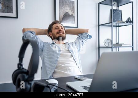 Uomo che si appoggia alla scrivania Foto Stock