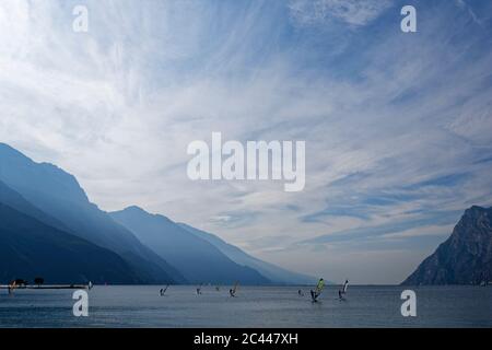 Italia, Trentino, Torbole, windsurf sul Lago di Garda circondato da montagne Foto Stock