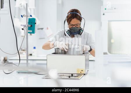 Una donna affidabile che esegue ricerche mentre utilizza apparecchiature mediche in laboratorio Foto Stock