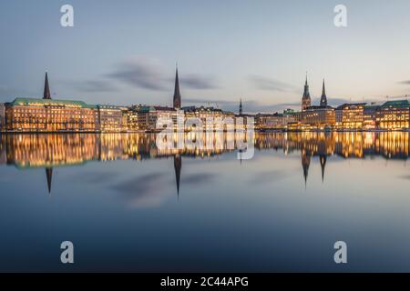 Germania, Amburgo, edifici che si riflettono nel lago interno di Alster al tramonto Foto Stock