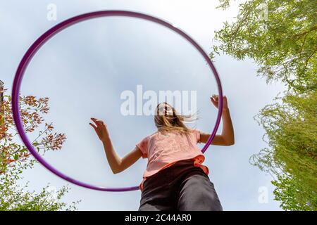 Ragazza con la hula in giardino Foto Stock