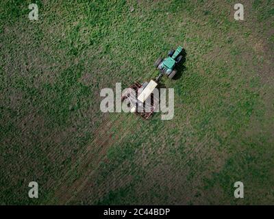 Russia, Vista aerea del campo verde di aratura del trattore Foto Stock