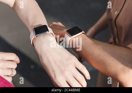 Mani di uomini d'affari che indossano orologi intelligenti all'aperto Foto Stock