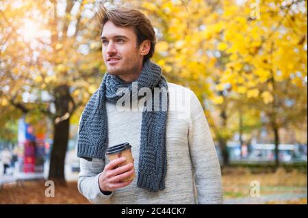 Ritratto di giovane con caffè da andare in autunno Foto Stock