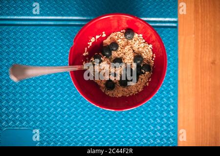 Primo piano di muesli con mirtilli in ciotola sul tappetino per esercizi Foto Stock