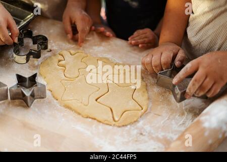 Vista ritagliata dei bambini che tagliano i biscotti Foto Stock