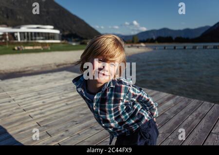 Happy boy in piedi sul lungomare di Achensee, Tirolo, Austria Foto Stock