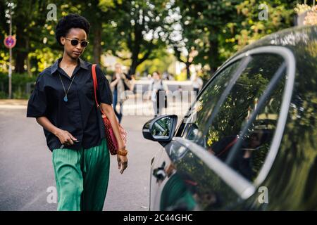 Ritratto di giovane donna che sblocca la sua auto Foto Stock