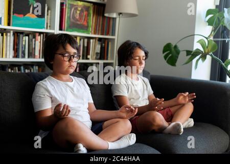 Fratelli seduti sul divano meditando Foto Stock