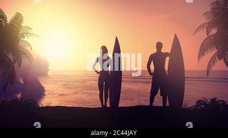 Sagome di surfisti su una spiaggia tropicale al tramonto. Foto Stock