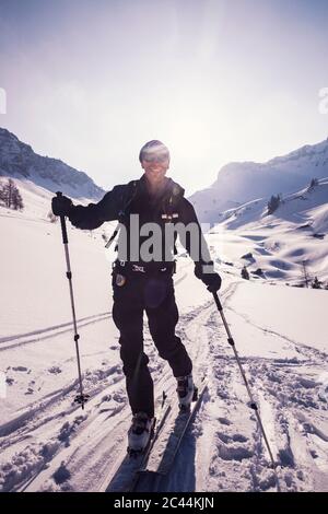 Felice escursionista sciare sulla montagna innevata ad Achenkirch, Tirolo, Austria durante la giornata di sole Foto Stock