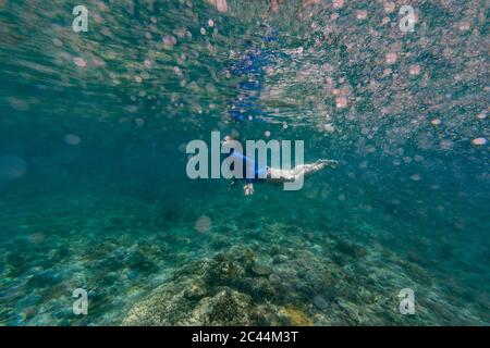 Indonesia, Bali, giovane donna snorkeling a Nusa Penida isola Foto Stock