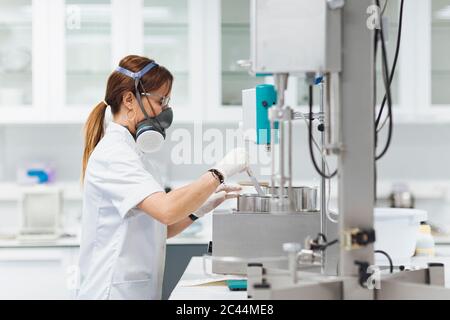 Medico sicuro che fa la ricerca mentre usa le attrezzature mediche in laboratorio Foto Stock