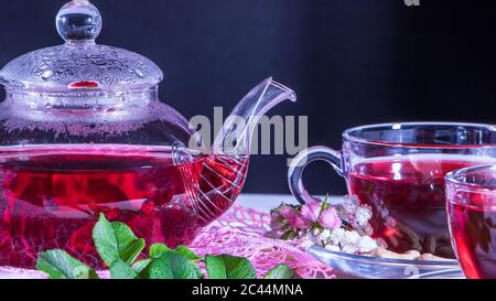 Tè caldo di lusso con un piacevole odore in un accogliente home.relax drink.Teapot, tazze di tè, anacardi noci, fiori di chiodo di garofano e foglie verdi medicinali. Tè cer Foto Stock