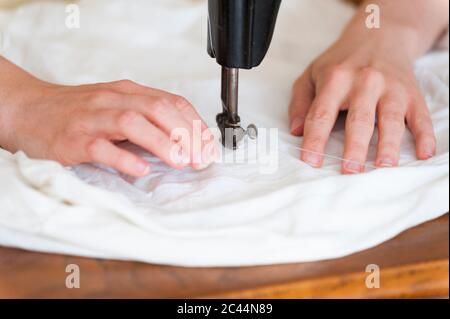 Mani della donna che usano la vecchia macchina da cucire, primo piano Foto Stock
