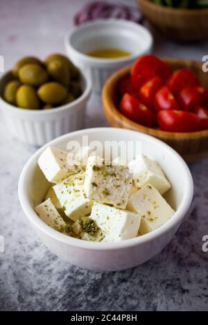 Ciotole con ingredienti freschi per insalata greca Foto Stock