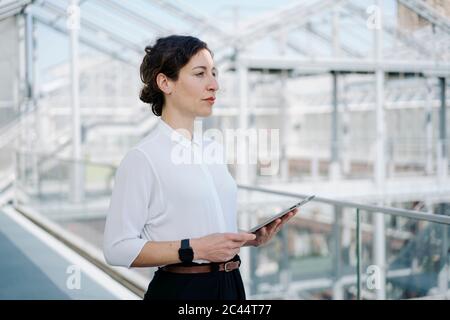 Imprenditrice azienda tablet cercando lateralmente Foto Stock