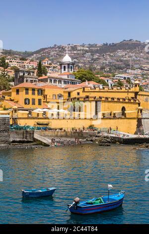 Portogallo, Isola di Madeira, Funchal, Vista di Forte de Sao Tiago con barche da pesca in primo piano Foto Stock