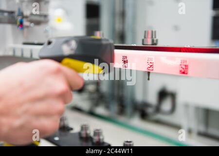 Primo piano di un uomo che utilizza lo scanner di codici a barre in fabbrica Foto Stock