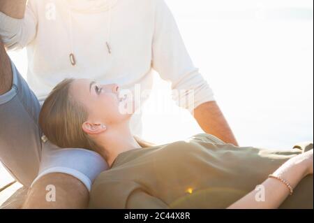 Felice giovane donna che si rilassa con il suo ragazzo sul molo Foto Stock