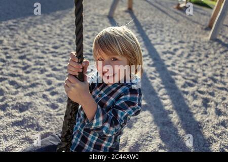 Happy boy che si cede in corda ad Achensee, Tirolo, Austria Foto Stock