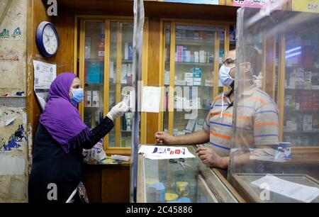 Cairo, Egitto. 23 Giugno 2020. Una donna che indossa una maschera facciale parla con un assistente di negozio in una farmacia al Cairo, Egitto, 23 giugno 2020. L'Egitto ha confermato il Martedì 1,332 nuove infezioni COVID-19, aumentando il numero totale di casi registrati nel paese da metà febbraio a 58,141, ha detto il Ministero della Salute egiziano. Credit: Ahmed Gomaa/Xinhua/Alamy Live News Foto Stock