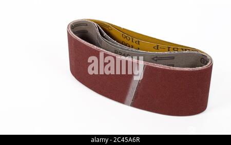 Strumenti costruzione e riparazione - carta smeriglio per macchine su sfondo bianco. Foto Stock