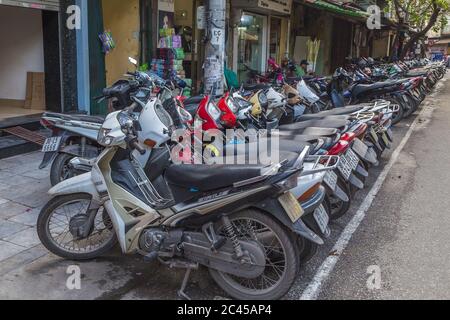 HANOI, VIETNAM - 19 MARZO 2017: Grandi quantità di moto e scooter parcheggiati lungo le strade di Hanoi durante il giorno Foto Stock