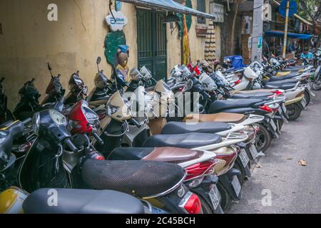 HANOI, VIETNAM - 20 MARZO 2017: Grandi quantità di moto e scooter parcheggiati lungo le strade di Hanoi durante il giorno Foto Stock