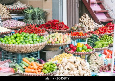 Grandi quantità di verdure in esposizione ad un mercato in Hanoi, Vietnam. Comprese le carote, i peperoni, le cipolle, i lime e i cetrioli, Foto Stock