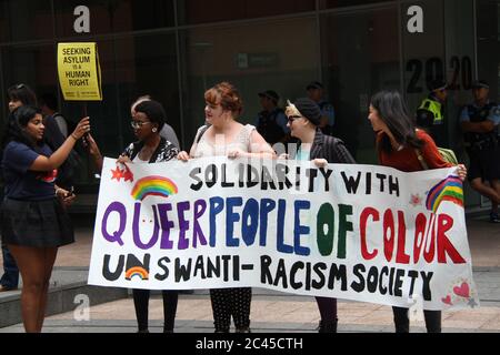 I manifestanti al rally hanno un banner che dice, ‘Solidarità con Queer People of Color. UNSW Anti-Racism Society». Foto Stock