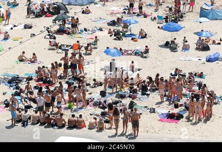 Bournemouth, Regno Unito. 24 giugno 2020. La gente si diverte sulla spiaggia di Bournemouth intorno all'ora di pranzo mercoledì 24 giugno durante una mini ondata di caldo che ha visto le temperature salire. Alcuni gruppi molto grandi sulla spiaggia, anche se la maggior parte delle persone è consapevole di mantenere la distanza sociale. Credit: Richard Crease/Alamy Live News Foto Stock