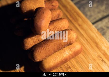 Colpo di primo piano di diversi cani da mais con un taglio in su su un tagliere su una superficie di legno Foto Stock