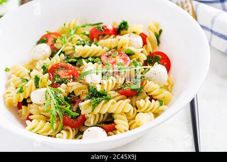Insalata di pasta. Pasta di fusilli - insalata caprese con pomodoro, mozzarella e basilico. Foto Stock