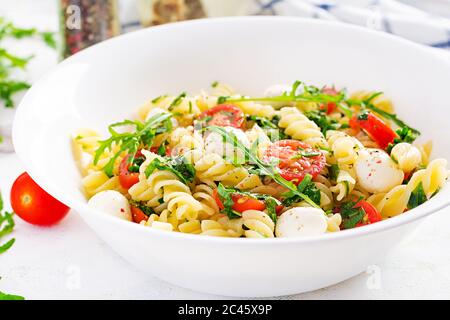 Insalata di pasta. Pasta di fusilli - insalata caprese con pomodoro, mozzarella e basilico. Foto Stock