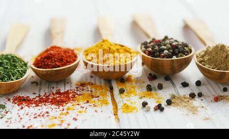 Cucchiai di legno con assortimento di spezie Foto Stock