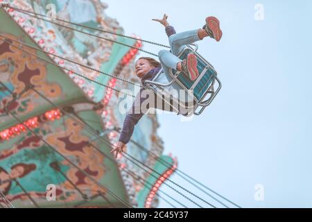 Giovane ragazza che si diverse a viaggiare in giostra sul Prater a Vienna Foto Stock