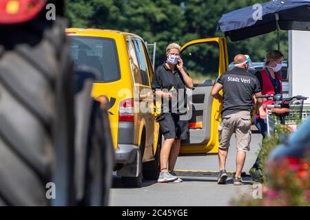24 giugno 2020, Renania Settentrionale-Vestfalia, Verl: Una postdonna porta la posta agli abitanti delle case che sono state messe in quarantena nel distretto di Sürenheide. Dopo l'epidemia di corona nel Tönnies, le autorità impongono un blocco anche per il distretto di Gütersloh e il distretto limitrofo. Foto: David Inderlied/dpa Foto Stock