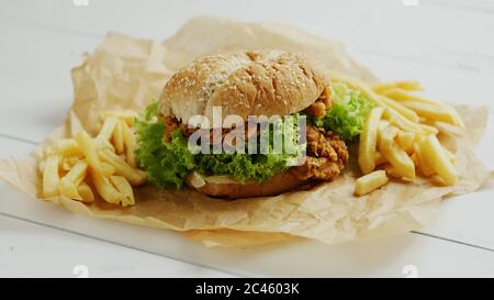 Le patatine e hamburger su pergamena Foto Stock