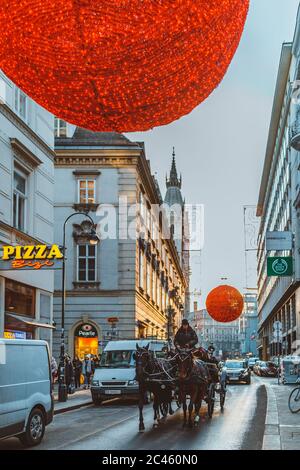 hackney trainato da cavalli in taxi per le strade di Vienna, decorato festivamente con bal di Natale rosso Foto Stock