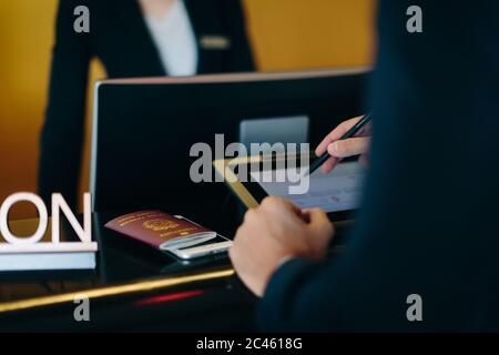 Imprenditore il check in presso la reception dell'hotel Foto Stock