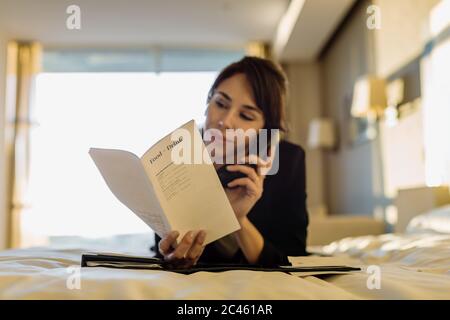 Imprenditrice ordinare il servizio in camera in hotel Foto Stock